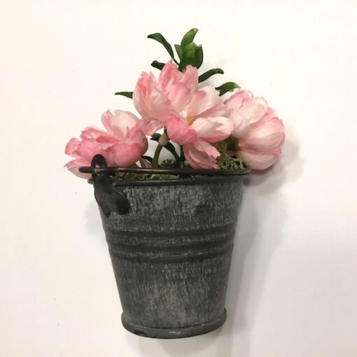 Lyserøde blomster i zinkpotte